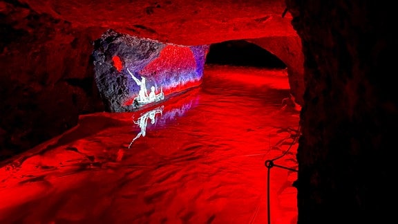 Rot-blaue Illumination eines Höhlenabschnitts.