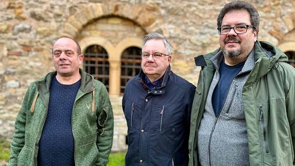 Drei Männer nebeneinander stehen im Innenhof der Creuzburg