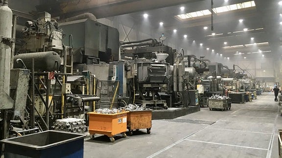 Eine große Lagerhalle mit meterhohen Maschinen.