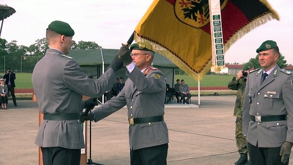 Brigadegeneral Alexander Krone übergibt die Truppenfahne des Bataillons vom bisherigen Kommandeur Dominik Schellenberger an den neuen Kommandeur Jan Cihar.