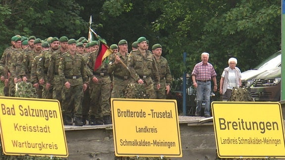 Bundeswehrsoldaten marschieren auf einem Gelände.