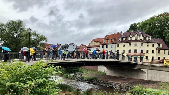  Mehrere Menschen stehen auf einer Brücke in Eisenach.
