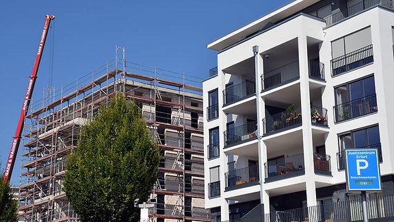 Ein fertiges und ein entstehendes Wohnhaus an einer Wohnungsbaustelle in Erfurt.