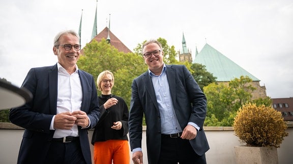 Portraits: v.l. Georg Maier (SPD), Katja Wolf (BSW), Fraktionsvorsitzende, Mario Voigt (CDU-Fraktionsvorsitzender) vor der Kulisse von Dom und Severi