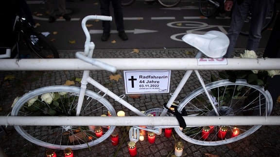 Ein weißes Rad zur Erinnerung an eine getötete Radfahrerin, darunter Kerzen