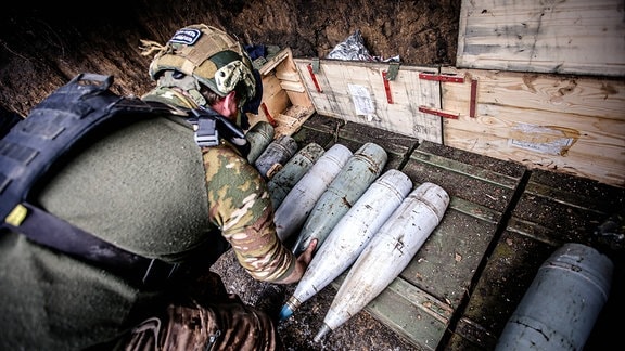 Ukrainischer Artillerist mit Artillerie-Granaten
