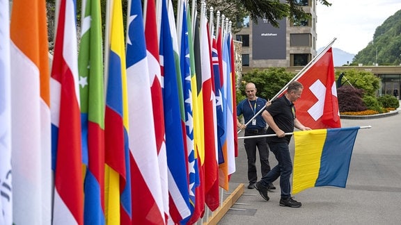 Männer mit den Flaggen der Schweiz und der Ukraine während der letzten Vorbereitungen für den Friedensgipfel in Bürgenstock