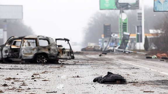 Leichen von Zivilisten liegen an einer Autobahn, 20 km von Kiew entfernt, neben einer Tankstelle. 