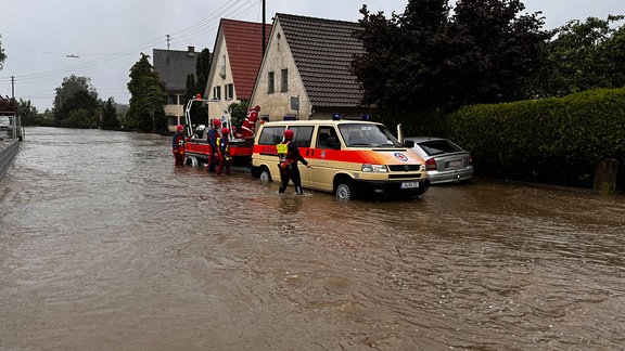 Die Wasserrettung ist in einer überschwemmten Straße in Diedorf im Einsatz.