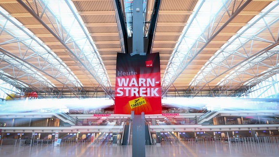 Ein Schild mit „Warnstreik“ hängt im Terminal 1 im Flughafen Hamburg