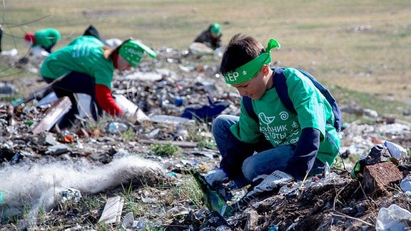 Ein Junge sammelt Müll am Baikalsee