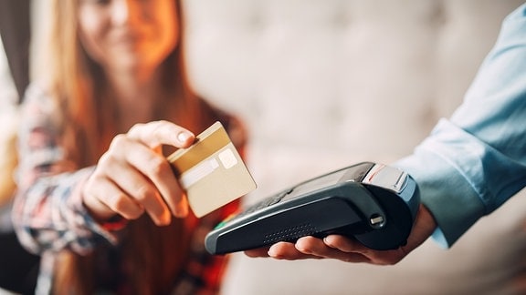 Eine Frau zahlt bargedllos mit einer Kreditkarte