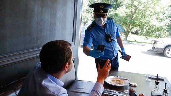 Ein Mitarbeiter der Stadt Moskau liest bei einer Razzia in einem Brooklyn Pizza Pie restaurant.