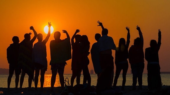 Menschen feiern 2015 den Sonnenaufgang des 1.Juli am Strand von Varna