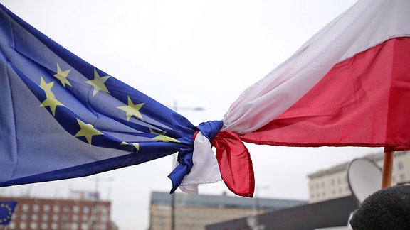 Flaggen der EU und Polens sind zusammengeknotet