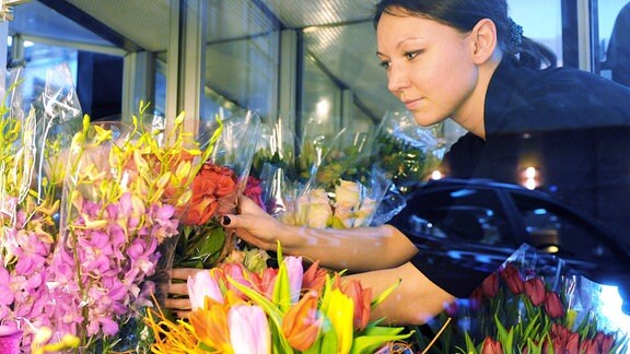 Frau arrangiert Blumensträuße im Moskauer NAT-Floristikstudio.