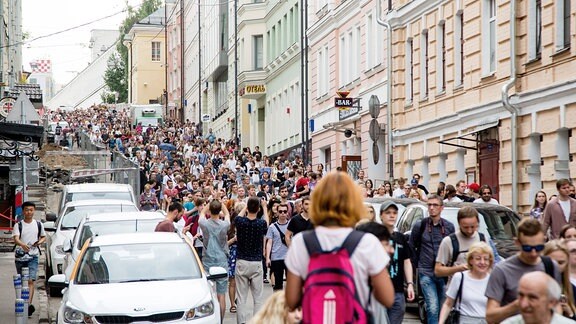 Große Menschenmenge marschiert durch eine Straße.