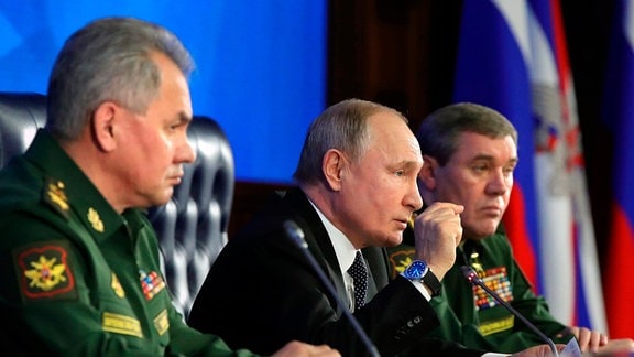 Wladimir Putin (M), Präsident von Russland, spricht neben Sergej Schoigu (l), Verteidigungsminister, während eines jährlichen Treffens mit den obersten Mitgliedern des Militärs