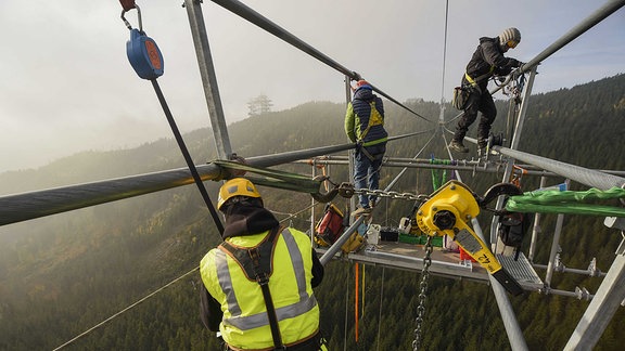 Monteure bei der Installation der Hängebrücke inm tschechischen Dolni Morava, in Luftiger Höhe