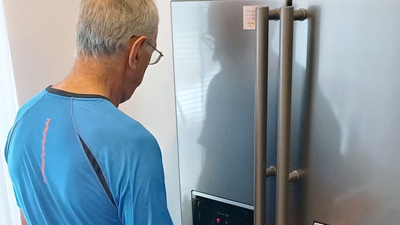 Eigenheimbesitzer Milan Sogel in seiner renovierten Küche am neuen, stromfressenden großen Kühlschrank