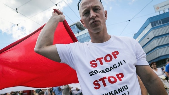 Mann mit polnischer Flagge auf einer Demonstration in Katowice gegen einen Impfzwang in Polen. 