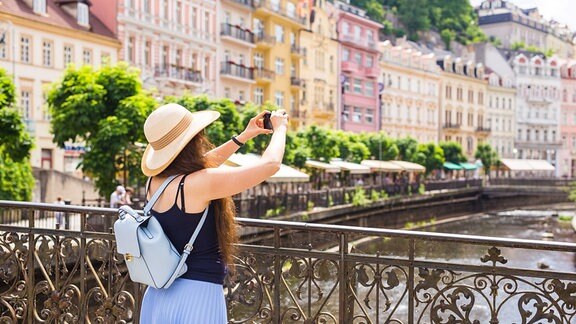 Eine Touristin knips in Karlsbad ein Foto
