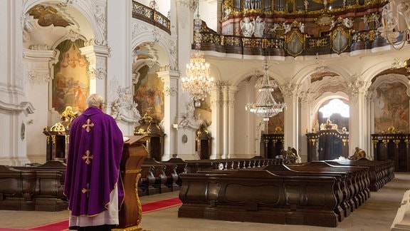Ein Priester zelebriert die Messe vor einer leeren Gemeinde in der Basilika von Krzeszow.