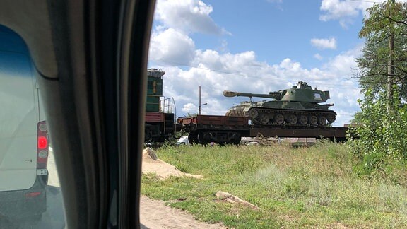 Ein Zug beladen mit Panzern und anderem Kriegsgerät passiert eine Bahnschranke in Sewerodonezk.