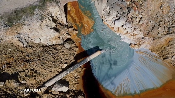 Abwasser aus Kupferbergbau läuft aus einem Rohr in einen See
