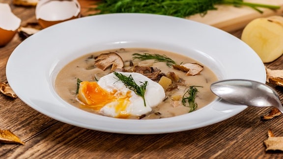 Tschechische traditionelle Suppe Kulajda mit Dill und Pilzen und pochiertem Ei.