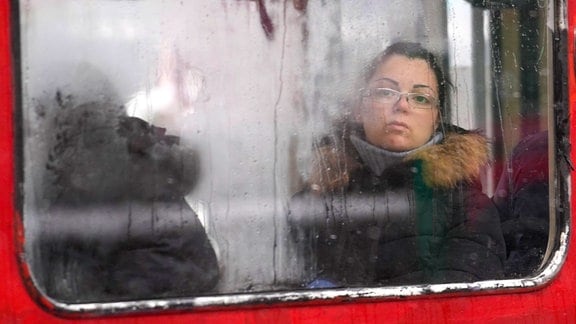 Eine Frau schaut durch ein Busfenster