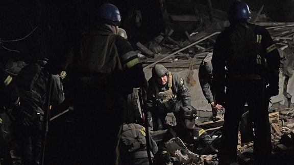 Rettungskräfte bergen die Leiche eines Opfers eines nächtlichen russischen Angriffs.