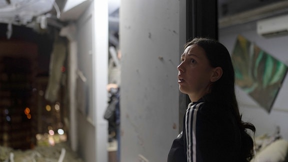 Eine Anwohnerin begutachtet die bei dem russischen Luftangriff beschädigte Wohnung ihres Nachbarn.