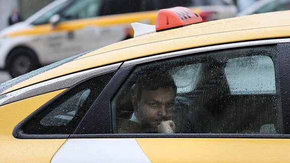 Ein Mann fährt im Taxi in Moskau