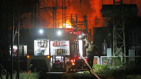 Feuerwehr vor einem brennenden Kraftwerk