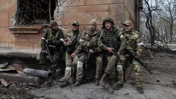 April 18, 2022, Russische Soldaten sitzen in der Nähe der Kampflinie in Mariupol.