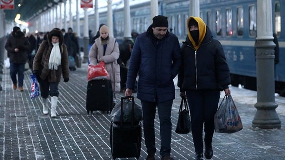 Reisende auf einem Bahnhof
