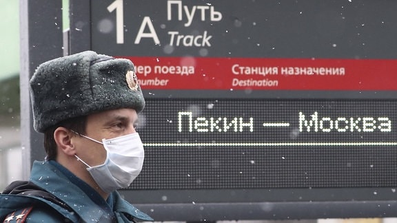 Ein Polizist in einer Gesichtsmaske am Jaroslawski-Bahnhof vor der Ankunft eines Zuges aus Peking, China
