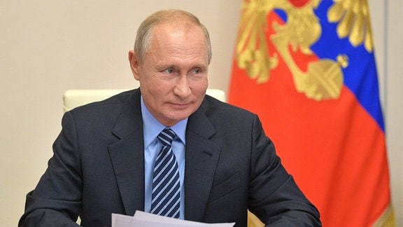 Präsident Putin sitz an einem Tisch während einer Videokonferenz.