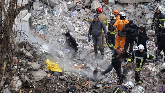 Nach einem russischen Dronenangriff beseitigen Rettungskräfte in Odessa die Trümmer eines zerstörten Wohnhauses. 