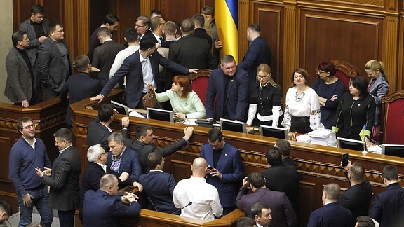 Parlamentarier blockieren eine Tribüne während einer Sitzung des ukrainischen Parlaments