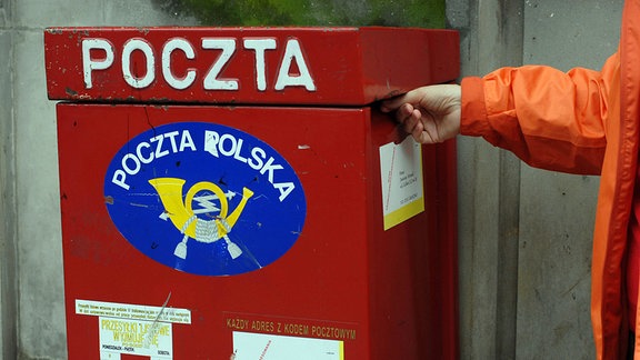 Ein roter Briefkasten mit polnischer Aufschrift. 