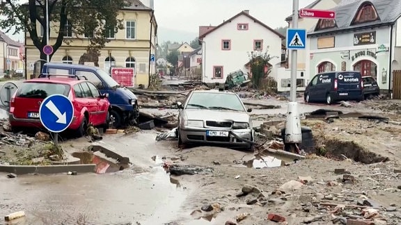 Trümmer, aufgerissene und schlammige Straße mit Autos in Tschechien.