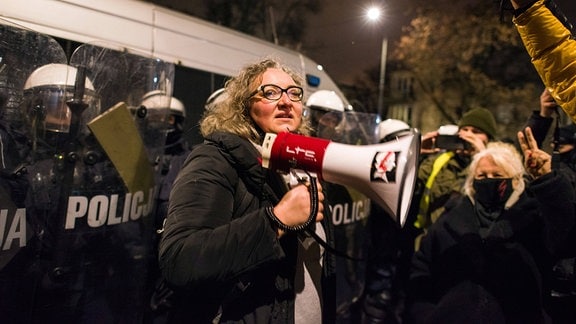 Eine Frau hält ein Megafon in der Hand.
