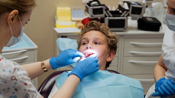 Zahnarzt kontrolliert die Zähne eines Jungen in einer Klinik in Prag.