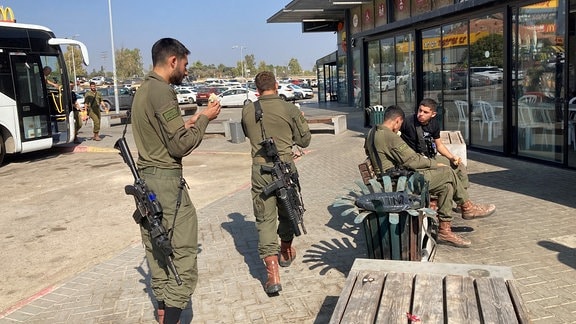 junge bewaffnete israelische Soldaten vor einem Supermarkt