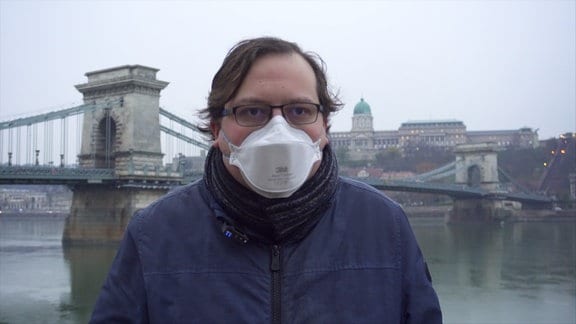 Mann mit Maske am Ufer der Donau in Budapest