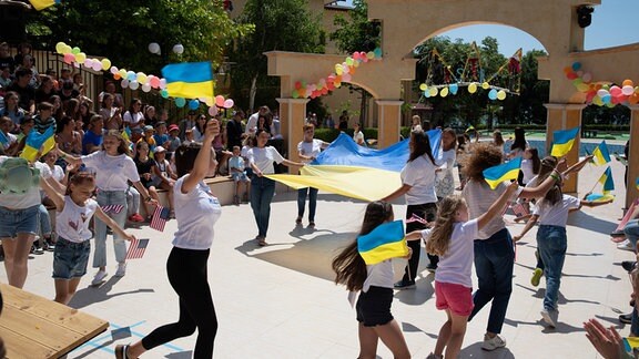 Gruppe junger Ukraine-Flüchtlinge tanzt auf einer Hotelanlage in Bulgarien.