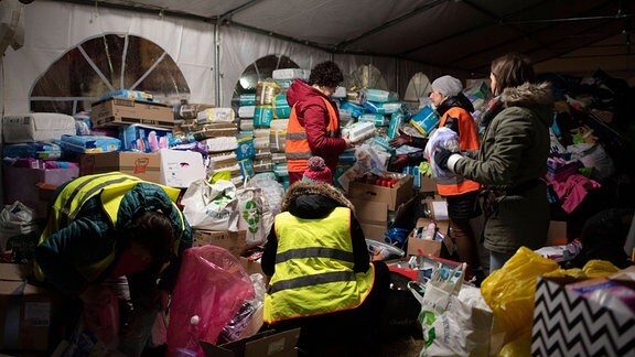 Freiwillige sortieren am Empfangspunkt in Przemysl Güter des täglichen Bedarfs.
