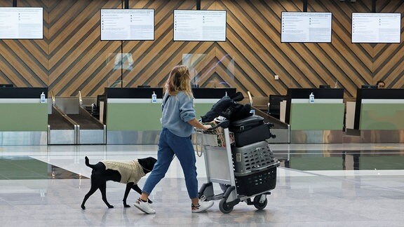 Eine Reisende schiebt einen Gepäckwagen in einem leeren Abfertigungsbereich des internationalen Flughafens Scheremetjewo